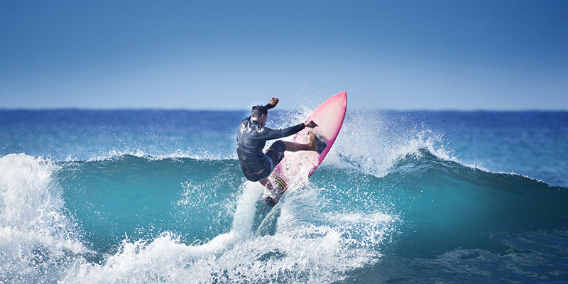 Young surfer surfing the wave of Kauai, Hawaii, USA.